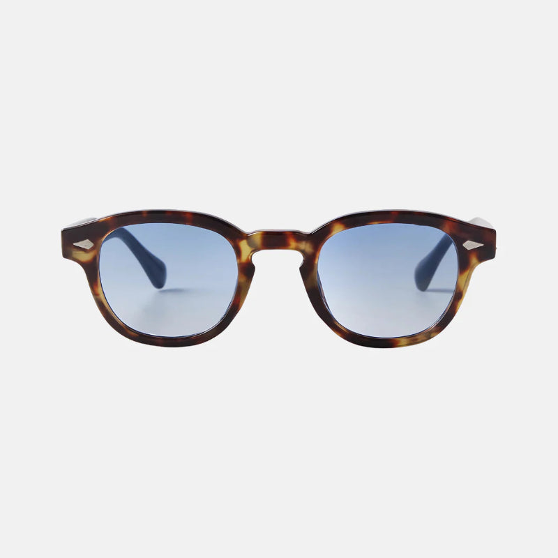 Sunglasses Vero Leopard Blue – tortoiseshell acetate frame with a mix of warm amber and dark brown tones, featuring round lenses with a striking blue gradient tint. The design includes keyhole bridge detailing and subtle silver accents at the temple front. www.zenluk.com