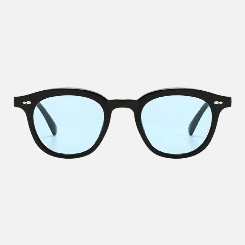 Sunglasses George Blue with a sleek black acetate frame and round lenses in a soft, cool blue tint. The frame features silver rivet accents on each side and a classic keyhole bridge. The clean white background highlights the contrast between the frame and lenses, making them stand out. Discover more at www.zenluk.com