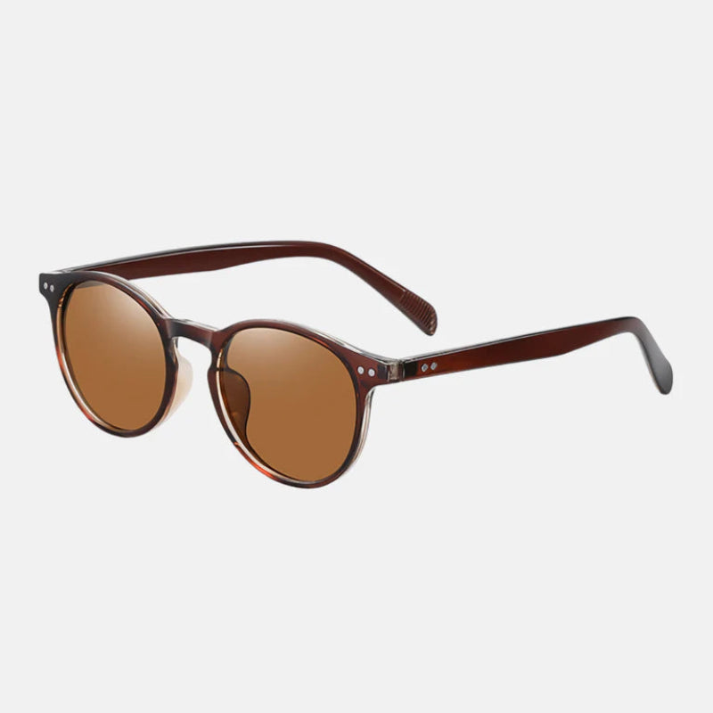 Sunglasses Lico Brown, shown at a three-quarter angle, showcasing the glossy deep brown acetate frame and warm brown-tinted lenses with a gentle mirror finish. The side view reveals the slender temples, metallic rivet detailing near the hinges, and slightly curved earpieces for comfort. A timeless and versatile design. www.zenluk.com