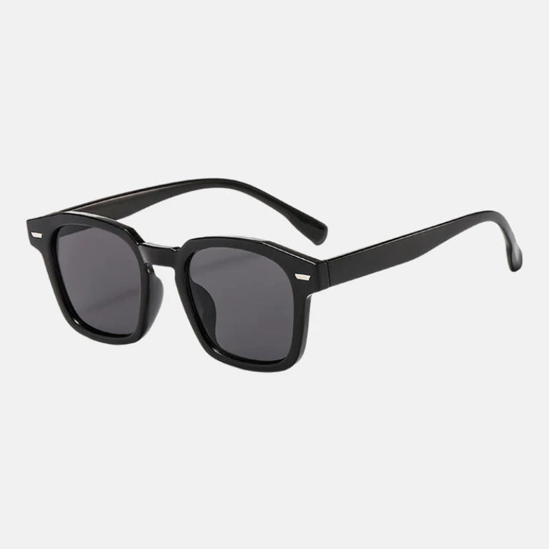 Sunglasses Noir Black – Rectangular sunglasses with slightly rounded edges, dark UV-protected lenses, discreet metallic detail near the hinges, and long, gently curved temples for comfort. Discover more at www.zenluk.com