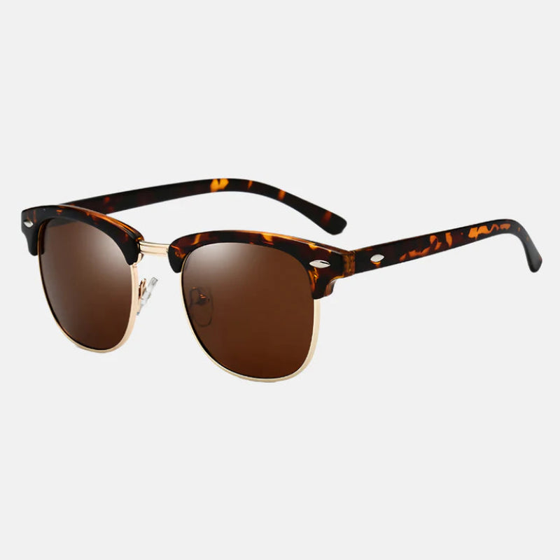 Sunglasses Ruby in tortoiseshell brown, angled side view. The frame showcases a classic semi-rimless silhouette with tortoiseshell acetate on the brow line, complemented by slim gold metallic rims beneath the lenses. The temples are tortoiseshell with sleek black tips, and the lenses feature a rich brown tint. Perfect for a timeless yet modern look. Explore at www.zenluk.com