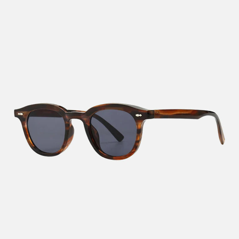 Sunglasses George Brown – Side profile showcasing the sleek tortoiseshell brown acetate arms with a comfortable fit. The smooth curves and silver rivet details highlight the timeless, vintage-inspired design. Fitted with deep gray UV-protected lenses, these sunglasses offer a perfect blend of luxury and practicality. Explore the collection at www.zenluk.com