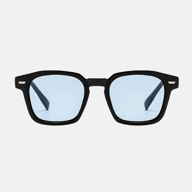Sunglasses Noir Black – Blue lens Rectangular sunglasses with slightly rounded edges, dark UV-protected lenses, discreet metallic detail near the hinges, and long, gently curved temples for comfort. Discover more at www.zenluk.com