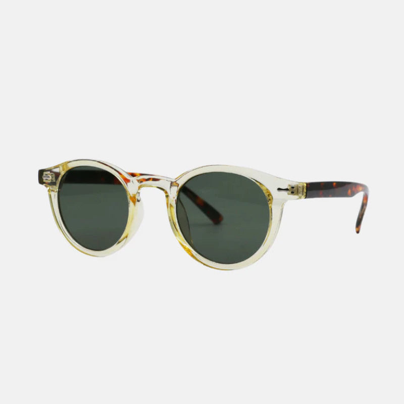 Sunglasses Vero Beige – side-angled view showing the transparent beige acetate frame with light amber gradients. Dark green polarized round lenses, keyhole bridge, and metallic hinge accents. The temples display a tortoiseshell pattern along the arms, ending with smooth tips for comfort. White background for a clean presentation. www.zenluk.com